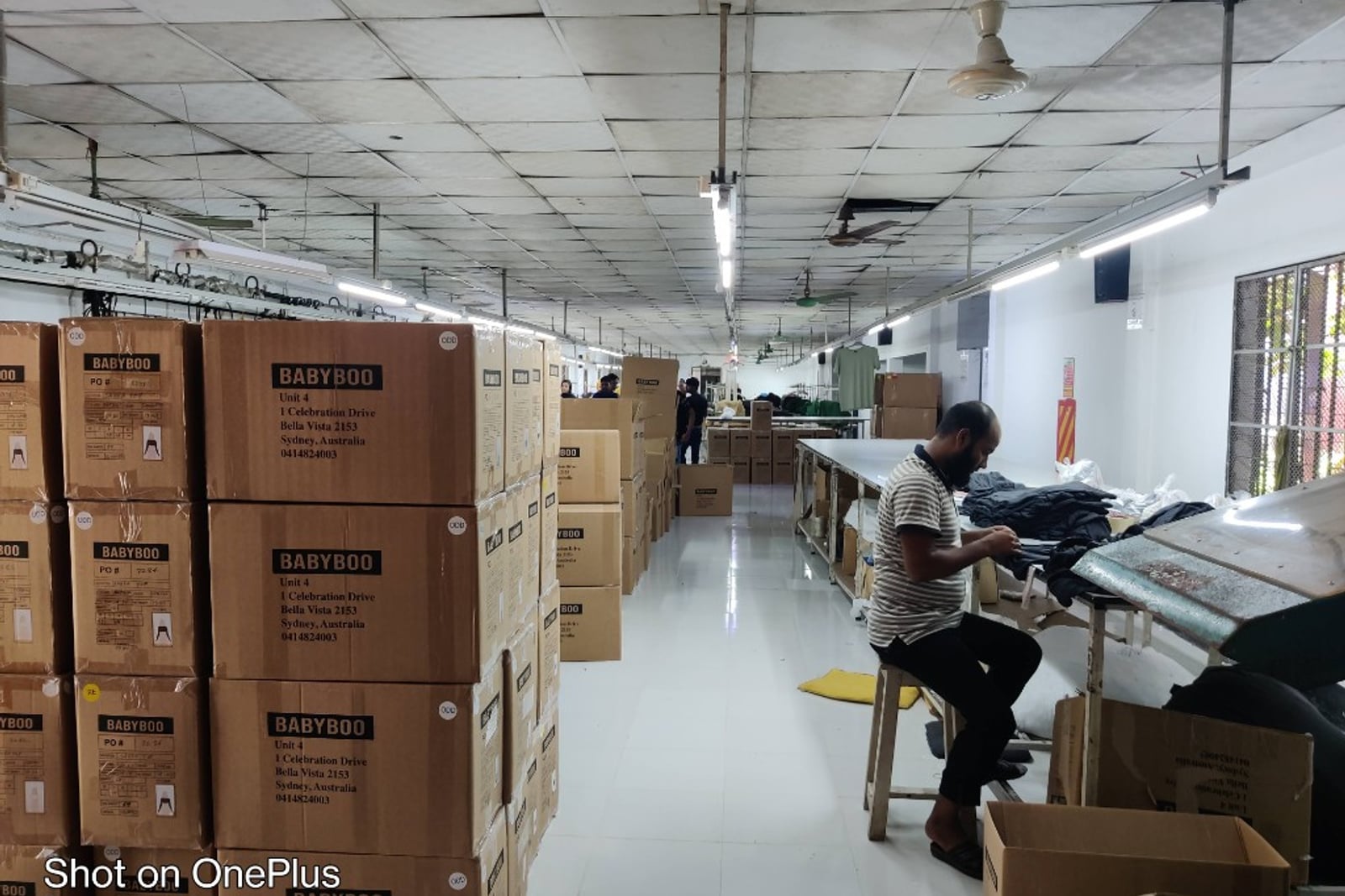 H & MR Supply Chain garments factory — warehouse packing tables and cartons ready for shipment